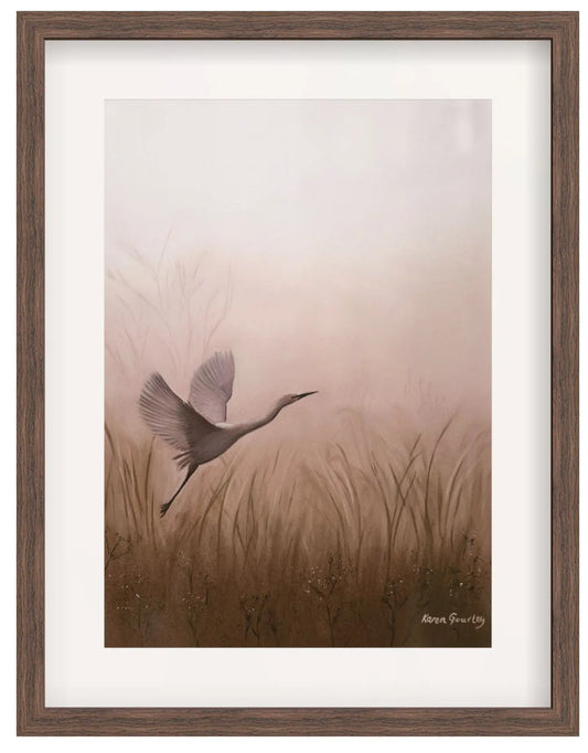 Framed artwork of a bird flying over grass with a wooden frame.