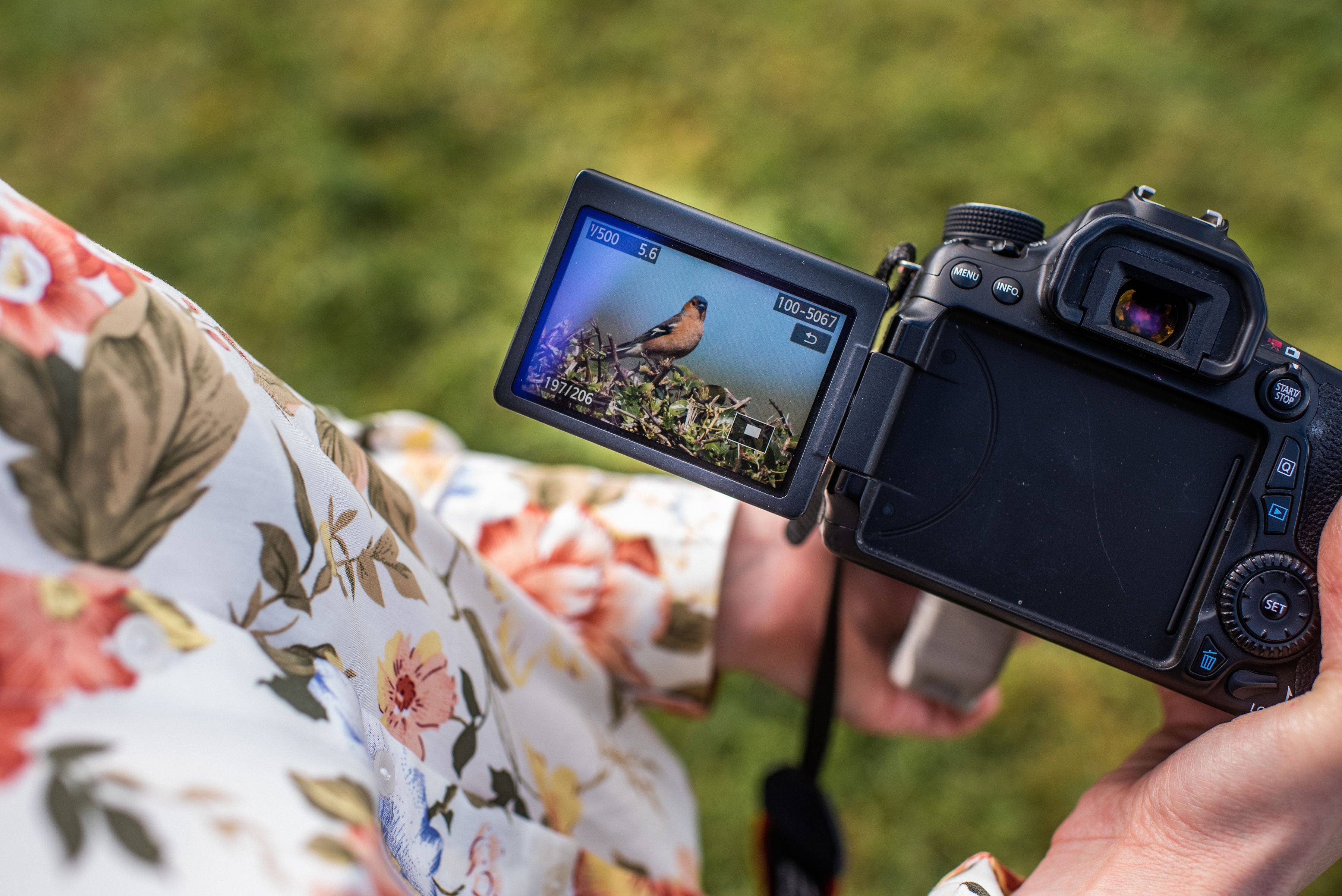Karen Gourley holding a camera with a photo of a chaffinch