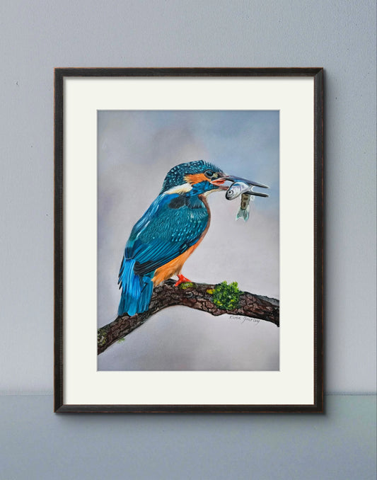 A framed art print of a kingfisher perched on a branch with a fish in its beak, against a blue background.
