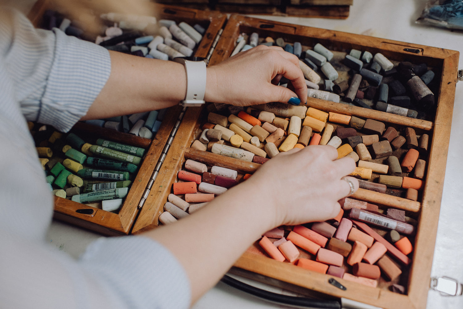 Karen Gourley selecting soft pastels from her wooden pastel box
