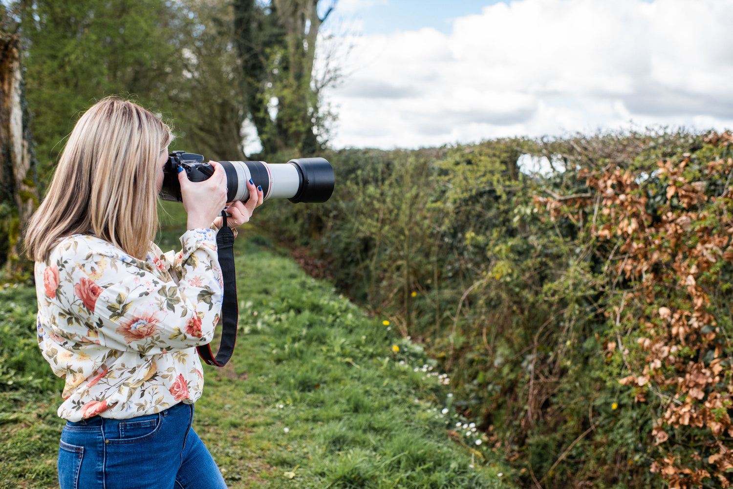 Karen Gourley taking a photo of birds in the hedgerows
