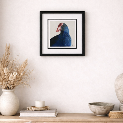 Framed artwork of a bird on a wall above a wooden console table with decorative items.